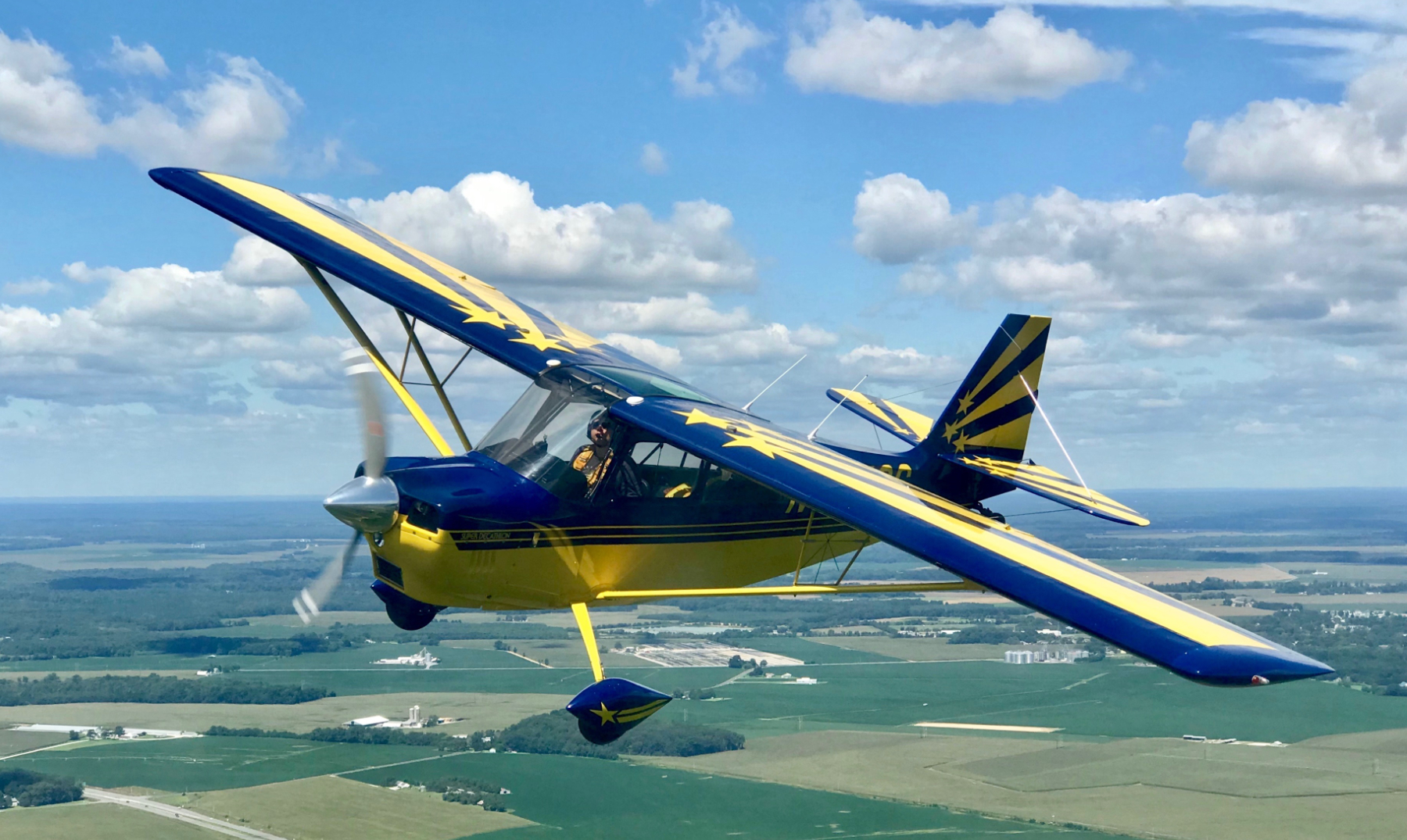 Blue and yellow Super Decathlon in flight